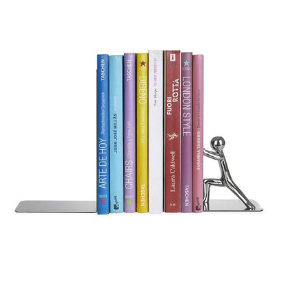 Metal bookend shaped like a little figure pushing a row of colourful books