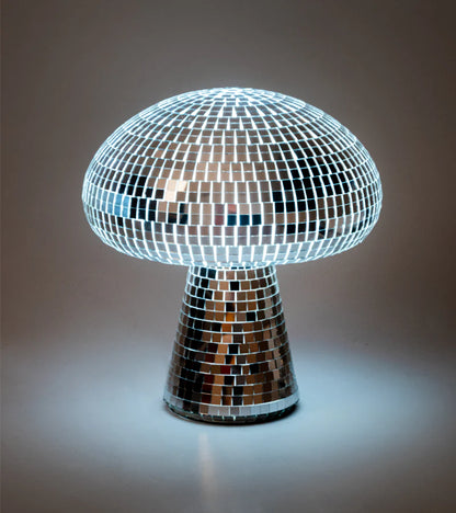 Mushroom-shaped lamp covered in disco-ball mirror tiles, lit on a dark background