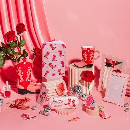 The Rodeo mug styled in a pink cowgirl-themed set, with boots, roses and disco balls.