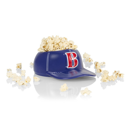 Baseball Cap bowl vase in blue with popcorn scattered around on a white background.