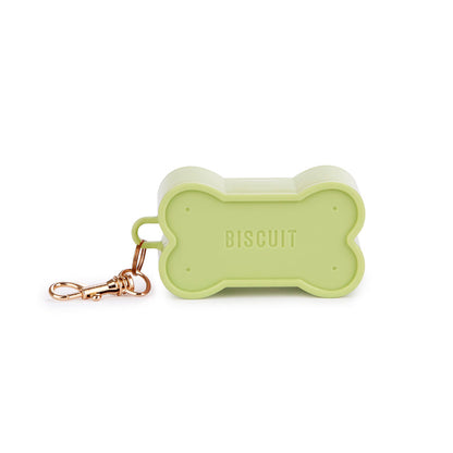 Green Biscuit dog waste bag holder, a hand holding it while pulling out the bag