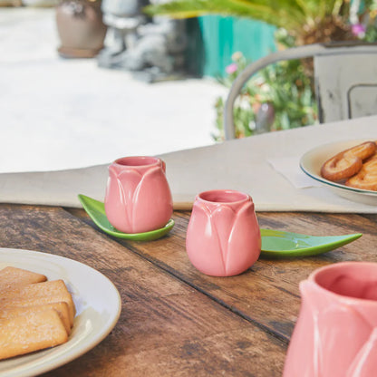 Pink Tulip coffee cup set with leaf-shaped saucers on a wooden table