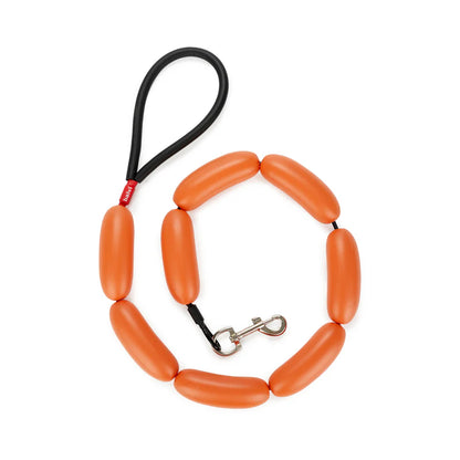 Hot Dog leash in orange, made of sausage-shaped links, with a black loop handle.