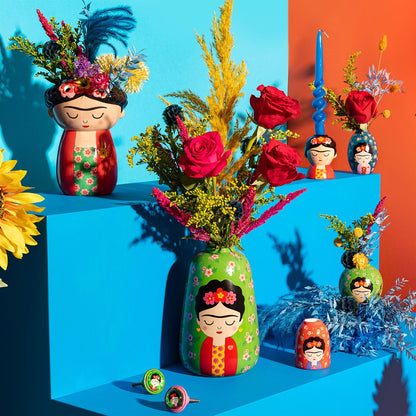 Vaso Frida Floral vases in several sizes with roses and dried flowers, on blue steps among candles.