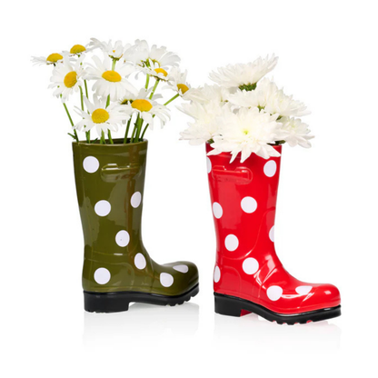 Wellington Pois boot vases in green and red with polka dots, both filled with white daisies.