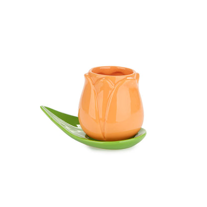 Orange Tulip cup on a green leaf saucer, on a white background