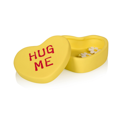 Hug Me heart box in yellow, open on a white background, with daisy earrings inside.
