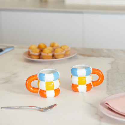 Float cup set on a marble counter with a spoon and a blurred plate of muffins