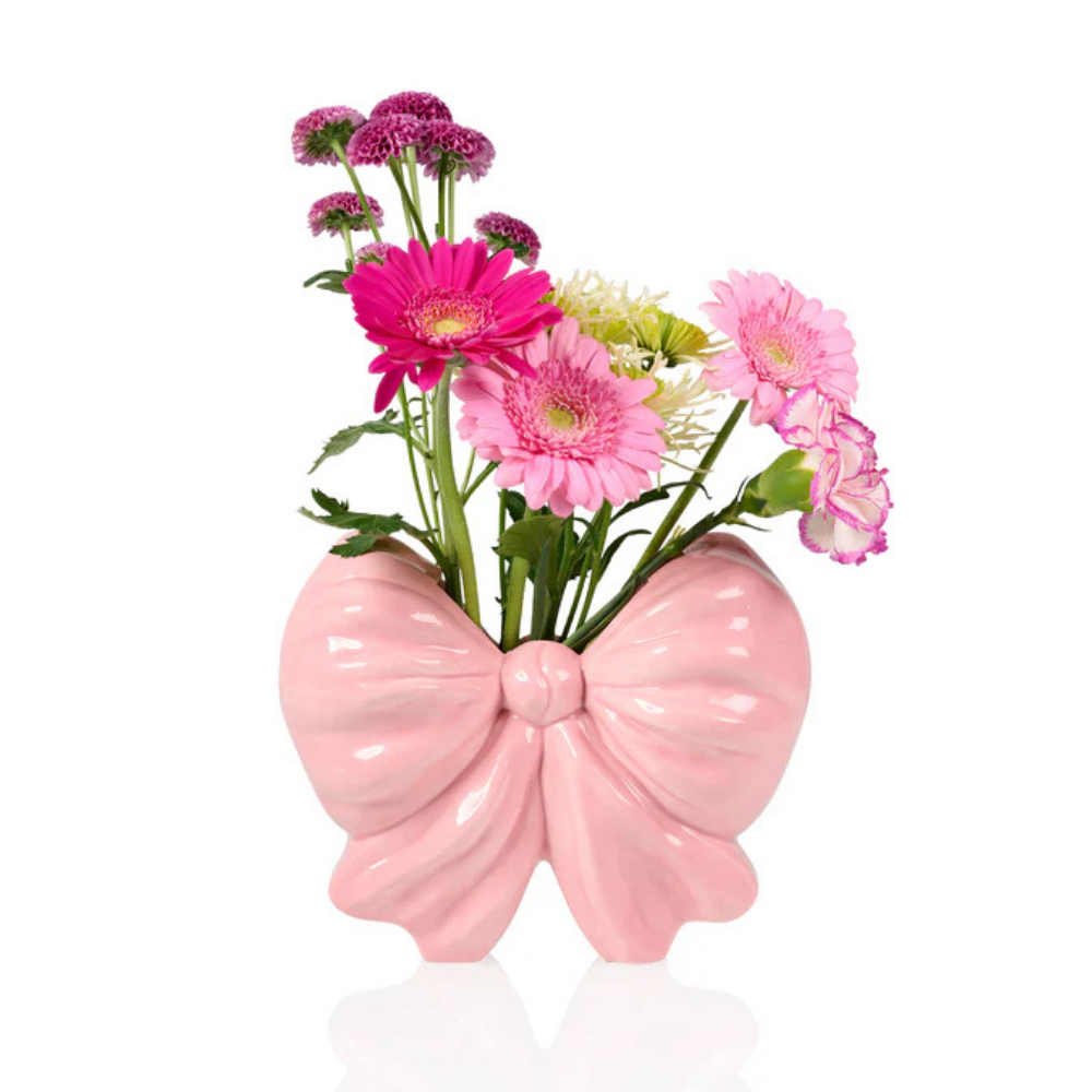 Fiocco bow-shaped vase isolated on white, with pink gerberas and white flowers.