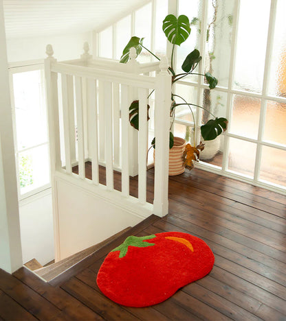 Tomato rug in red on a wooden floor near a staircase and a plant