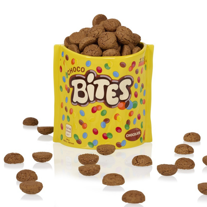 Choco Bites vase in yellow, filled with brown biscuits, some scattered outside.