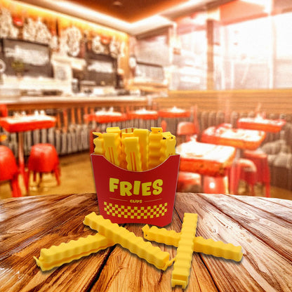 Fries food clips yellow fry-shaped clips, with the fry-box packaging on a wooden table.