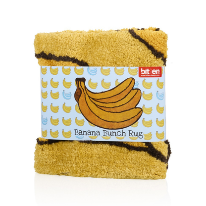 Banana Bunch rug folded, with an illustrated tag tied around it.