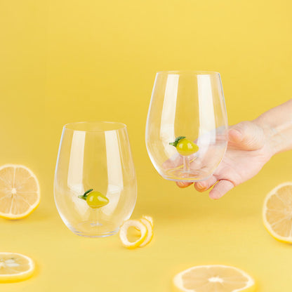 Botanical Lemon glass set, one glass held in a hand among lemon slices