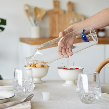 Atlantis Delfino bottle being tilted by a hand to pour water at the table