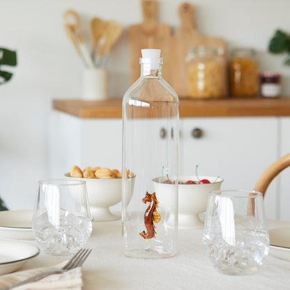Atlantis Seahorse bottle on a kitchen table with bowls of biscuits and cherries