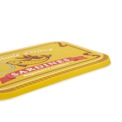 Sardines Trivet: a close-up of the corner of the yellow trivet with the sardine print.