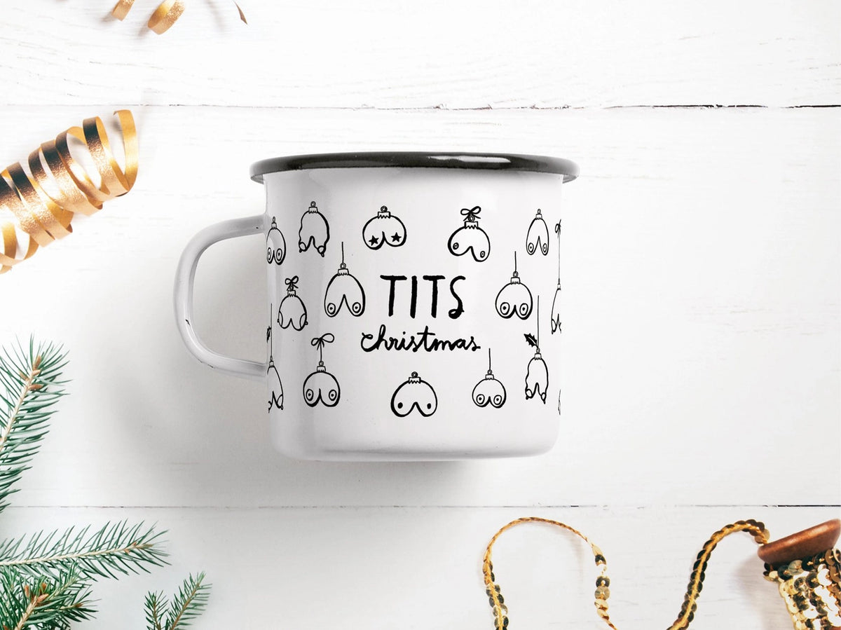 Tazza Tits Christmas: a white mug with breast-shaped bauble drawings and the words 'TITS christmas', styled with gold ribbon.