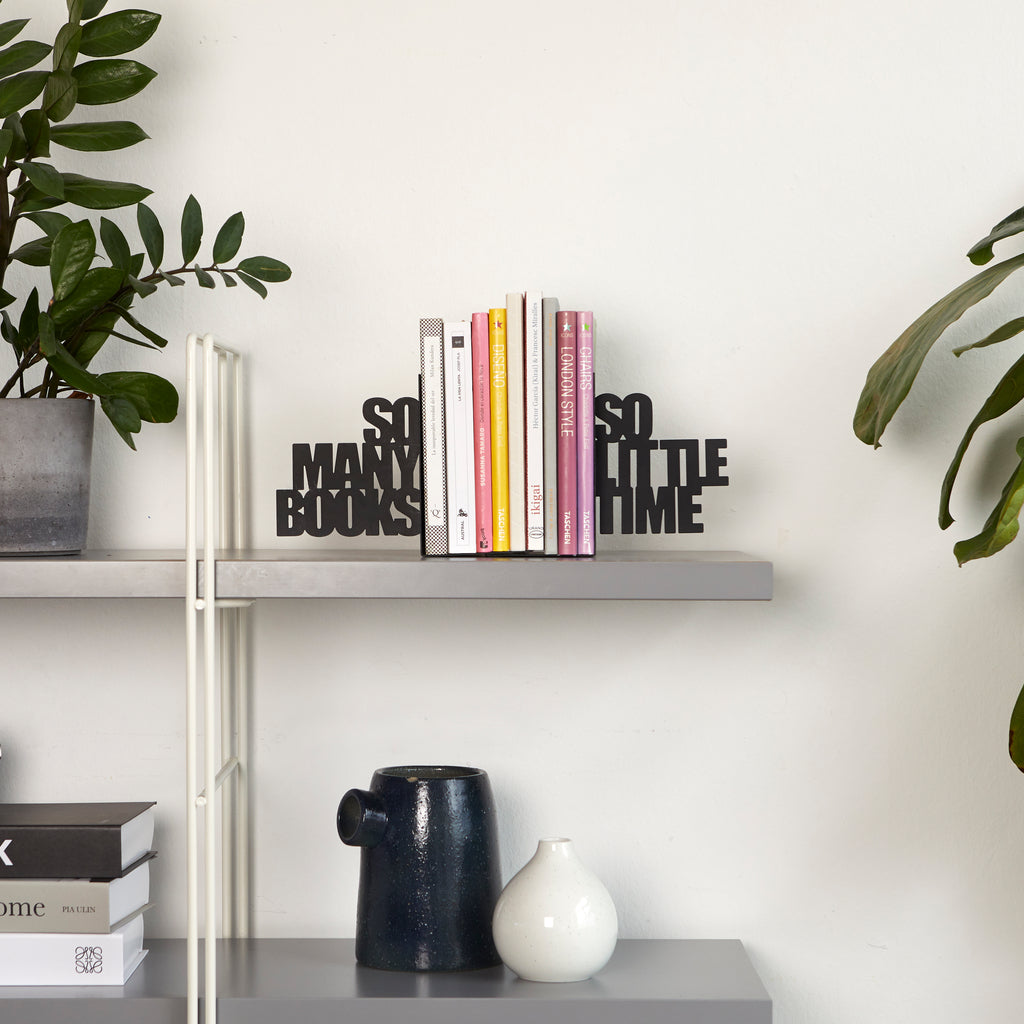 So Many! Bookend: the black lettering holding up the books on a living-room shelf.