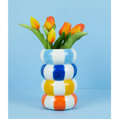Float Alto vase in blue, yellow and orange stripes with orange tulips, blue background