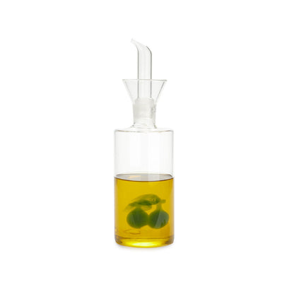 Olive oil cruet filled with oil, the olive decoration visible in the glass, white background