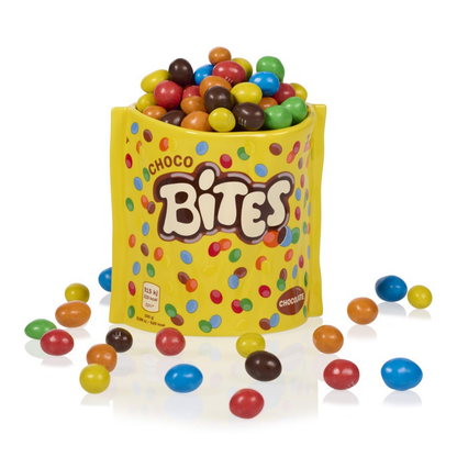 Choco Bites vase in yellow, filled with chocolate-coated sweets, some scattered outside.