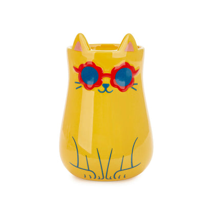 Yellow cat-shaped vase wearing red and blue sunglasses, on white