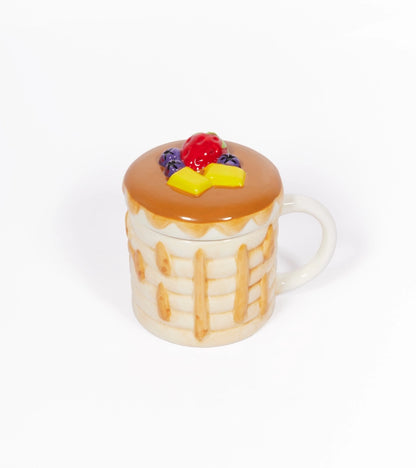 White mug shaped like a stack of pancakes, with butter and berries on the lid