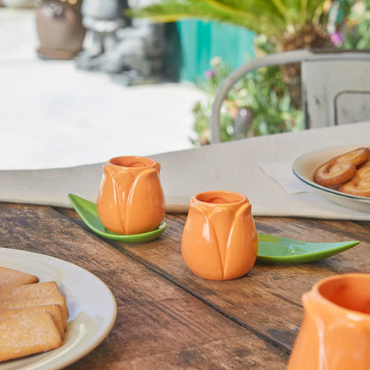 Orange Tulip coffee cup set with leaf-shaped saucers on a wooden table
