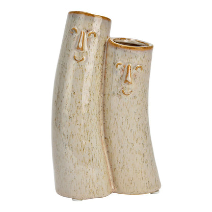 Couple vase: two cream-coloured vases with a smiling face carved into each, different heights, empty.