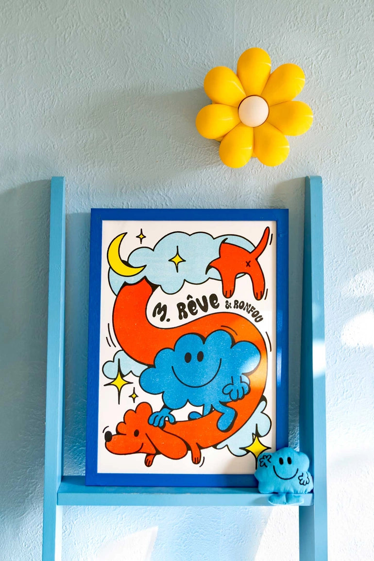 Mr. Daydream poster on a blue ladder shelf, with a yellow flower-shaped lamp and a dog figurine.