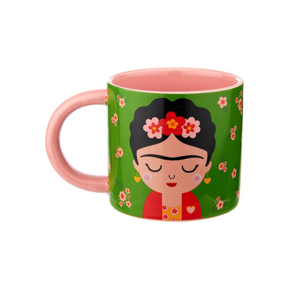 Tazza Frida: a pink mug with a pink handle, featuring a Frida-style face illustration on a green floral background.