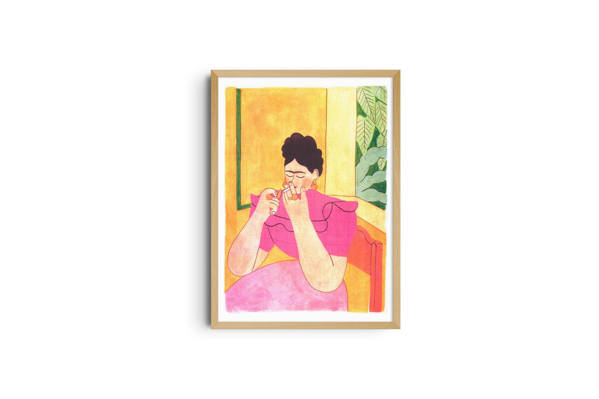 Poster Frida Kahlo incorniciato in legno chiaro, donna seduta con una tazza tra le mani su sfondo giallo