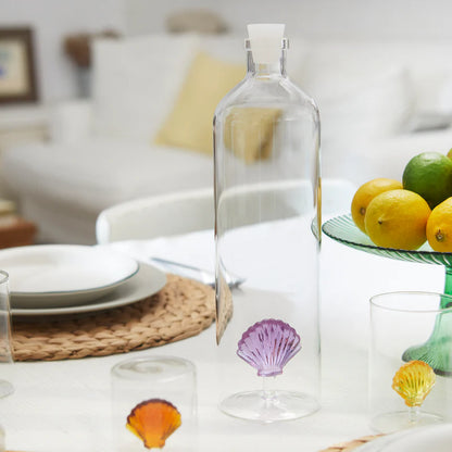 Atlantis Shell bottle on a table set with plates and lemons