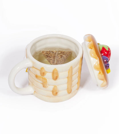 Pancake mug open with a tea bag inside and the pancake-shaped lid beside it