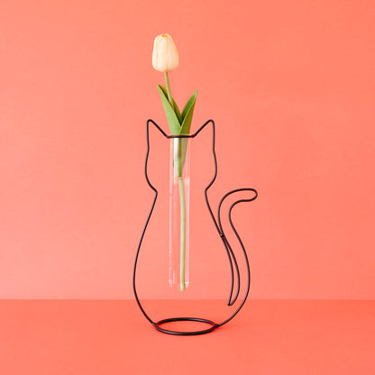 Cat Silhouette vase holding a white tulip, on a coral background