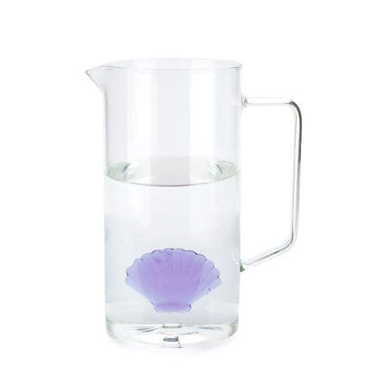 Caraffa Atlantis filled with water, the purple shell visible at the bottom, on a white background.