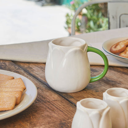 White Tulip mug on a wooden table with biscuits and more mugs