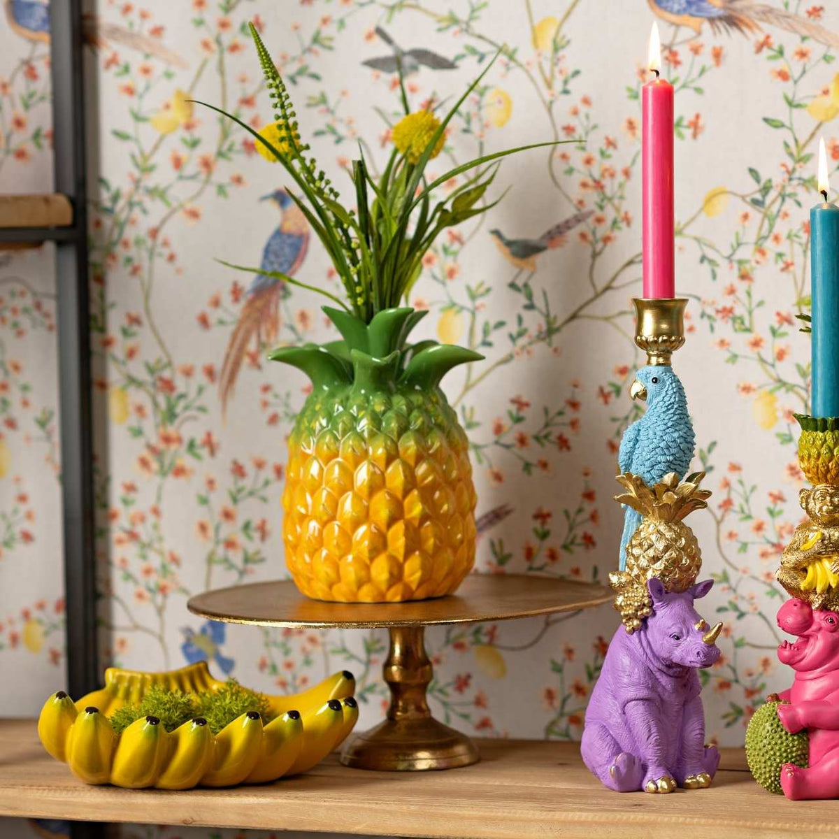 The Banana dish styled with a pineapple planter, gold candlesticks and colourful animal figurines.