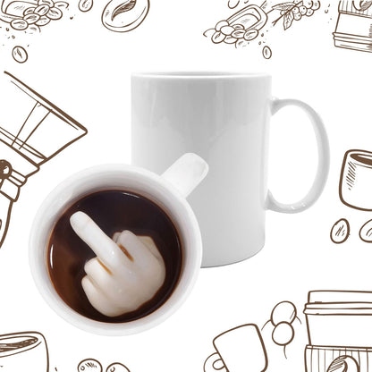 White mug seen from above with a middle finger printed at the bottom, in coffee