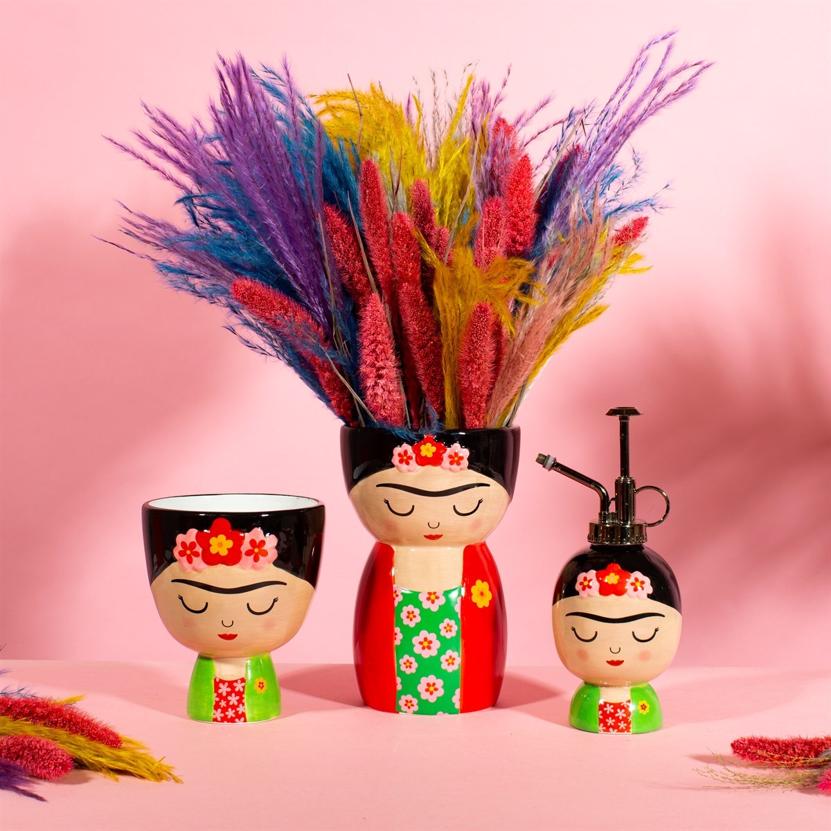 Vaso Frida in tre misure con erba pampas colorata, su sfondo rosa.